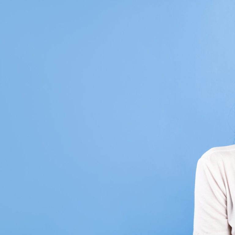 Portrait of curious beautiful lady biting lip and looking at copy space isolated over blue turquoise studio wall, banner