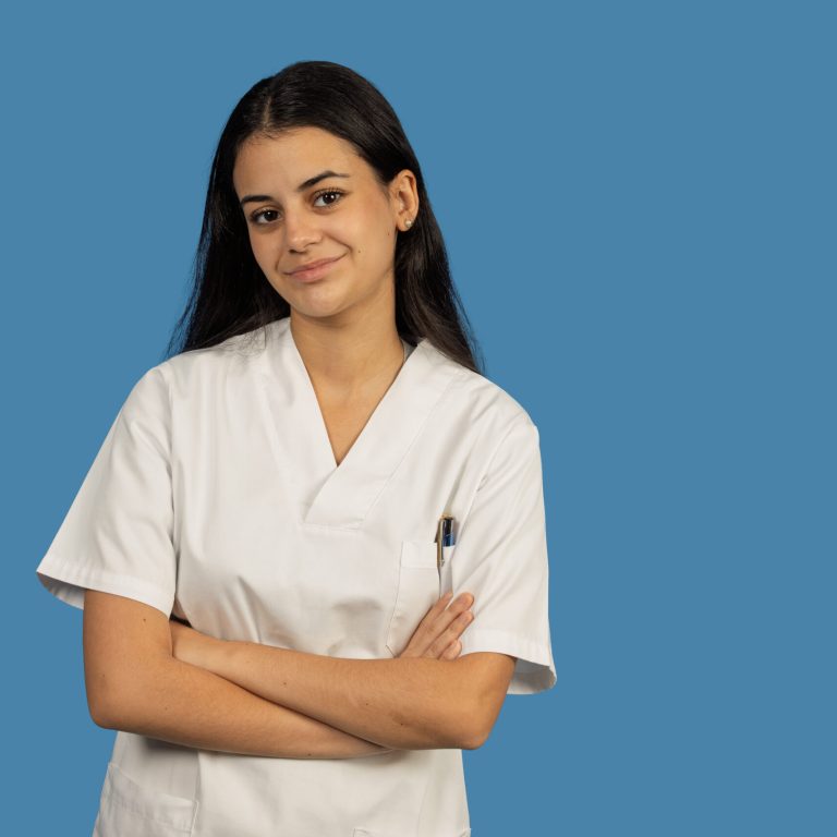 Young female nurse or medical professional standing with arms crossed, smiling at camera